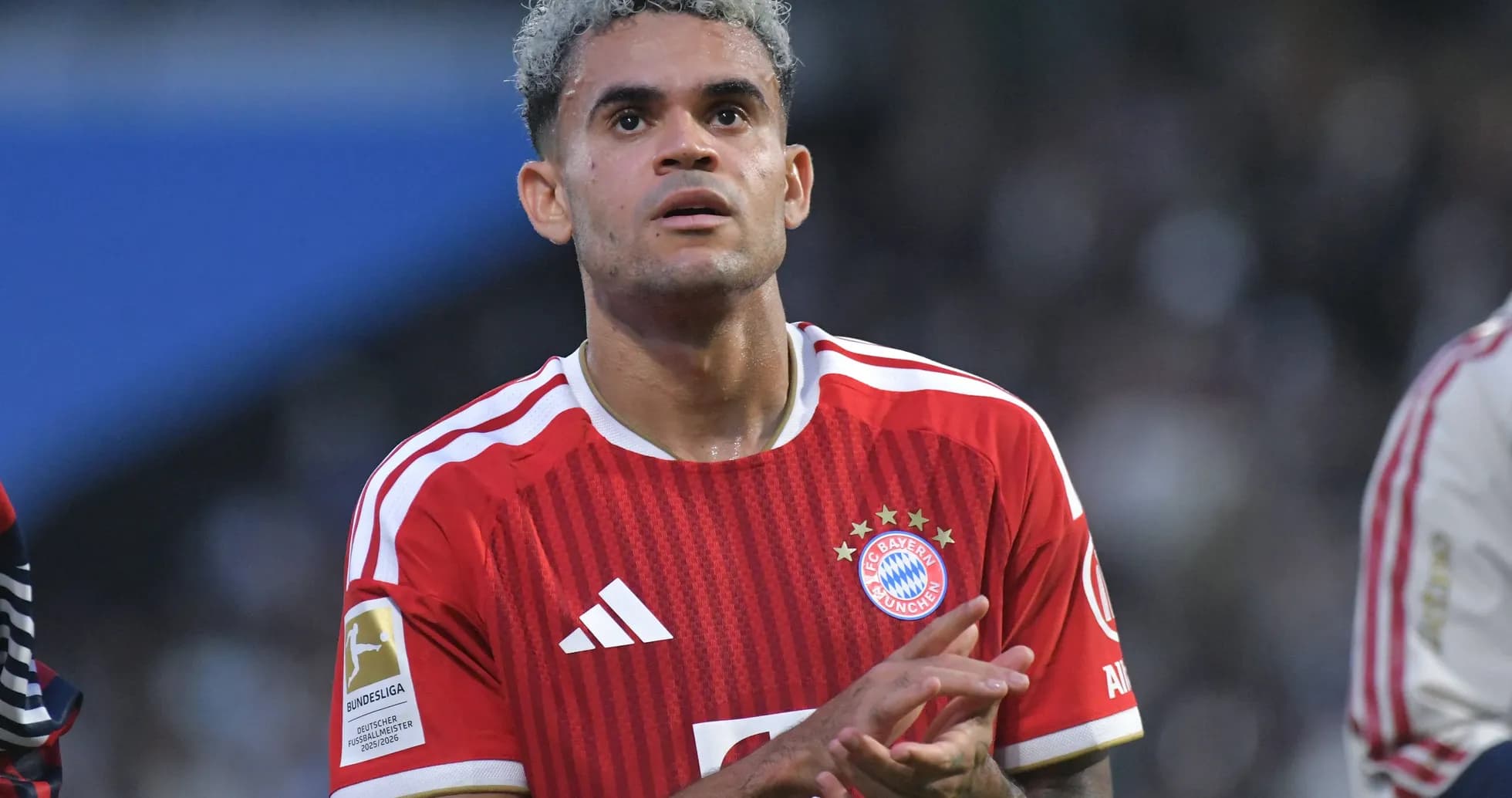 Player in Bayern Munich jersey clapping on field Player in Bayern Munich jersey clapping on field