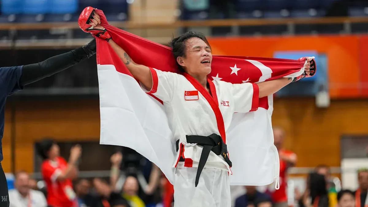 Martial artist celebrating with Singapore flag after victory Martial artist celebrating with Singapore flag after victory