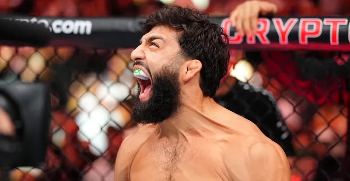Fighter celebrating with mouthguard in octagon Fighter celebrating with mouthguard in octagon
