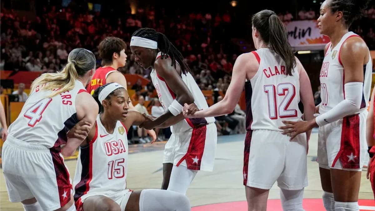 Team USA players assisting teammate on court Team USA players assisting teammate on court
