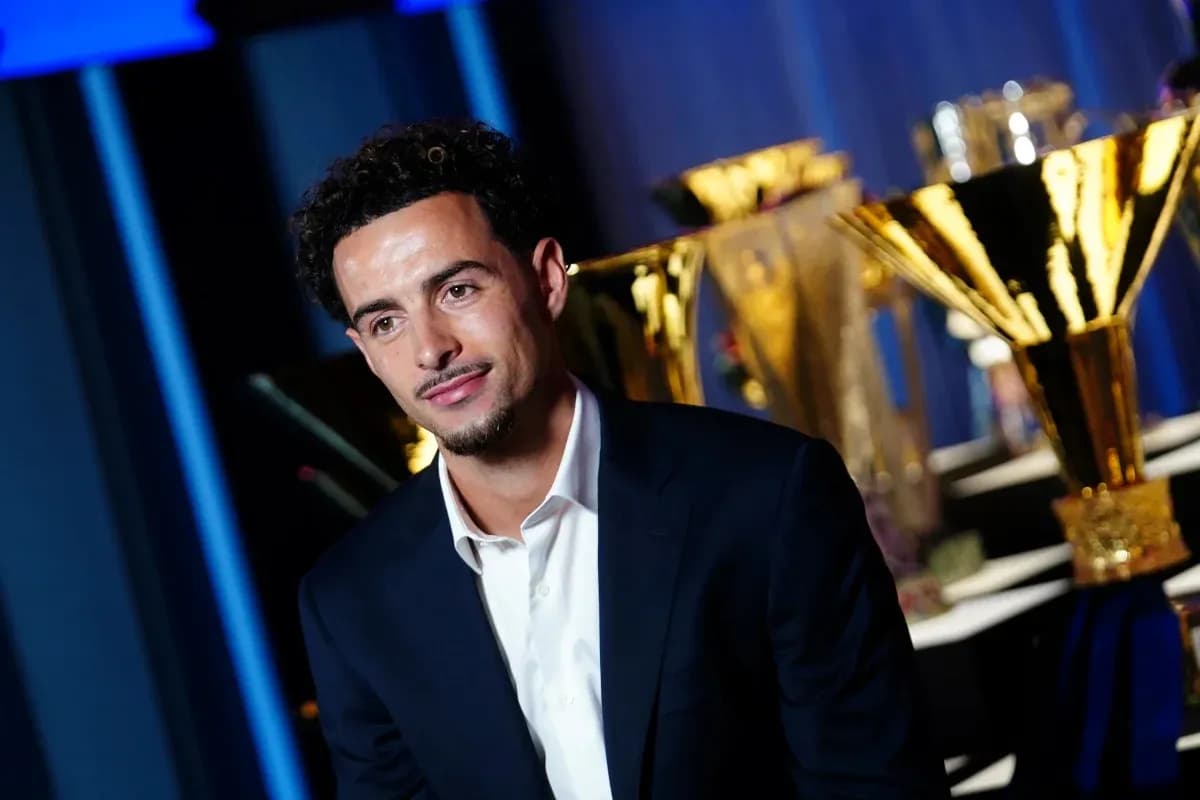 Person in suit with trophies in background Person in suit with trophies in background