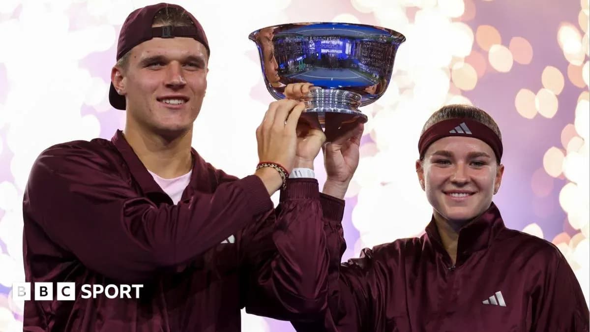 Two athletes celebrating with trophy on podium Two athletes celebrating with trophy on podium