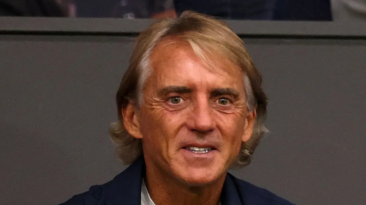 Man with light brown hair smiling at event Man with light brown hair smiling at event