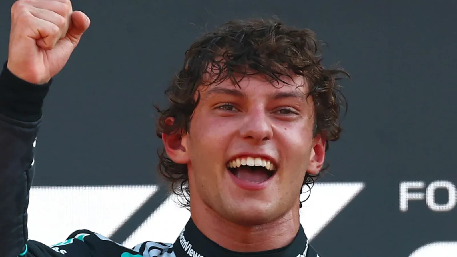 Driver celebrating victory with raised fist on podium Driver celebrating victory with raised fist on podium