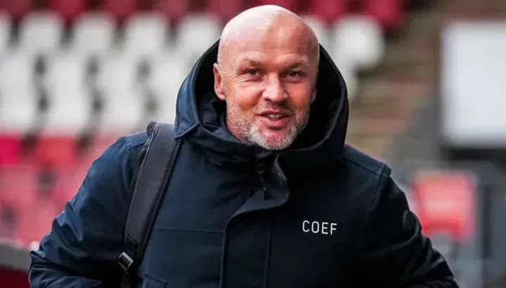 Man in coat smiling while entering stadium Man in coat smiling while entering stadium