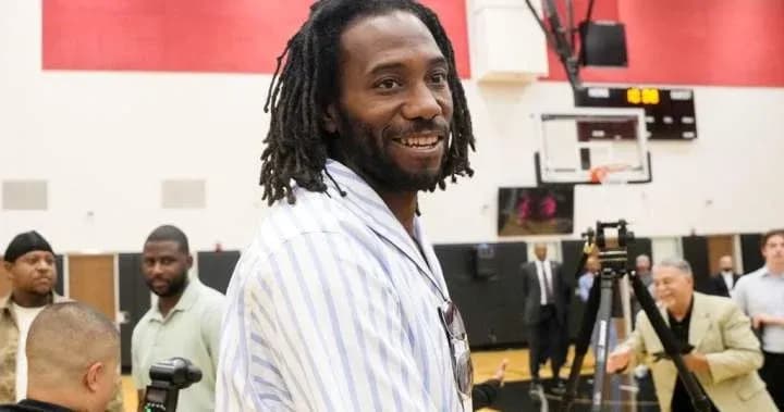 Man smiling during basketball event with attendees Man smiling during basketball event with attendees