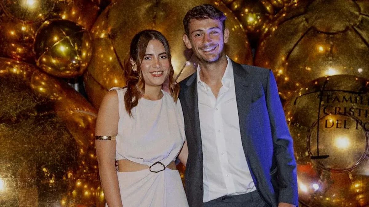 Two individuals posing together at event backdrop Two individuals posing together at event backdrop