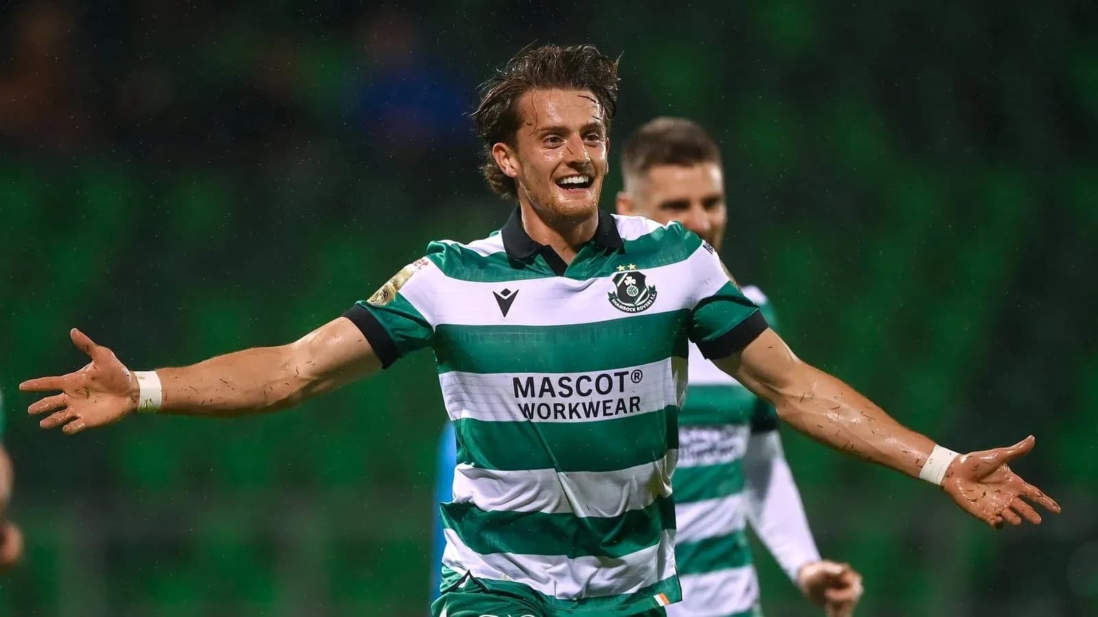 Player celebrating goal in striped green jersey Player celebrating goal in striped green jersey
