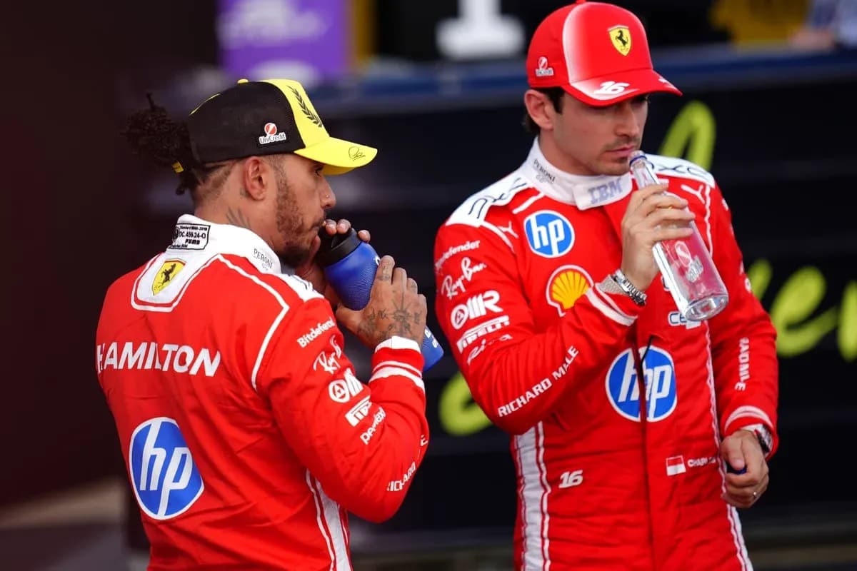 Two Formula 1 drivers drinking from bottles Two Formula 1 drivers drinking from bottles