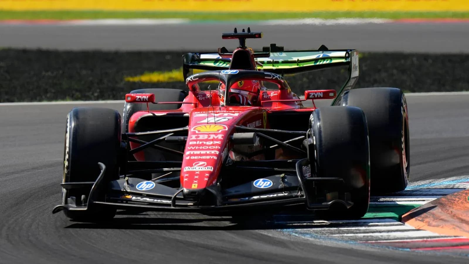 Ferrari F1 car navigating a corner on track Ferrari F1 car navigating a corner on track