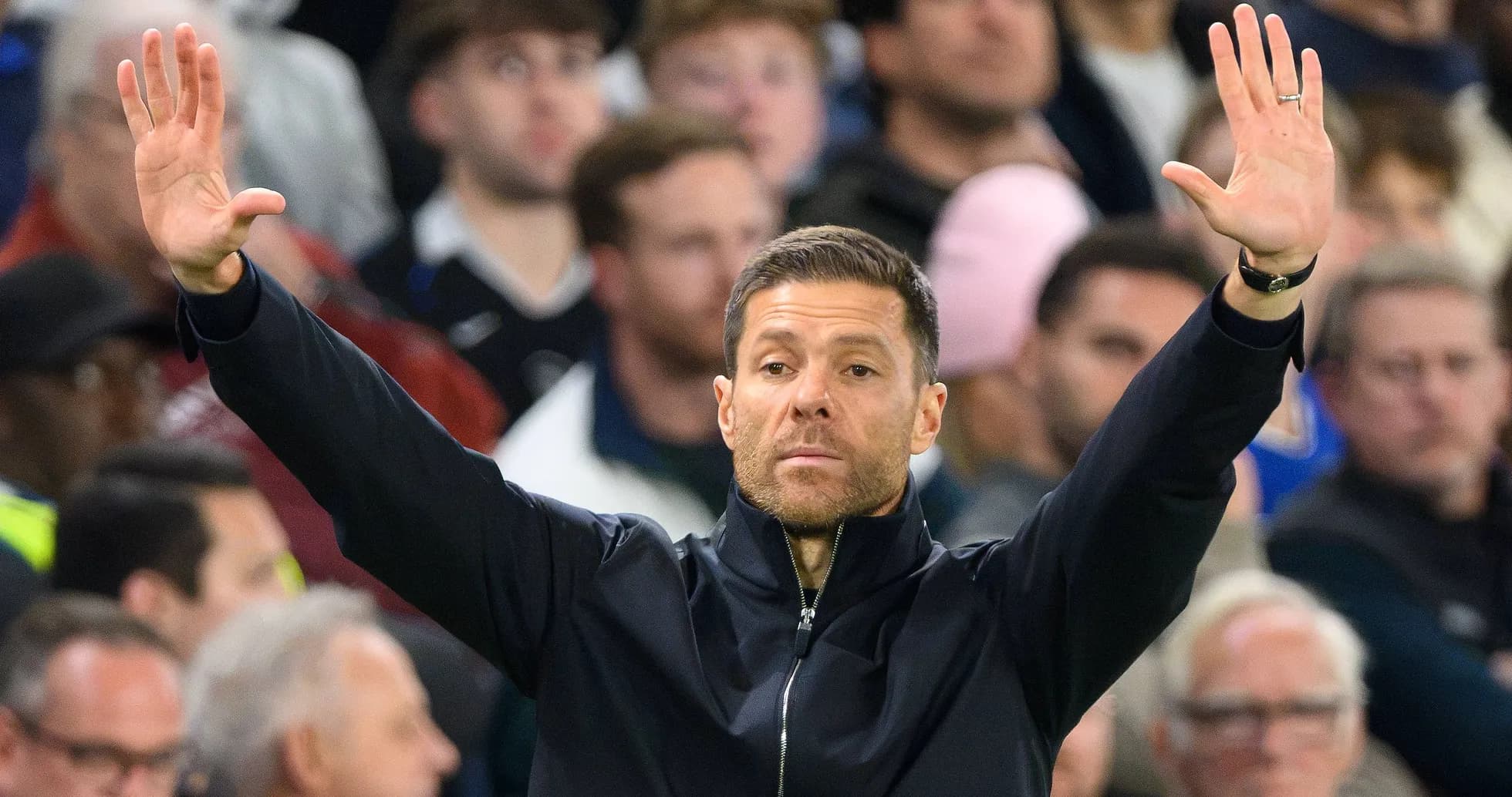 Coach gesturing during a match with fans in background Coach gesturing during a match with fans in background