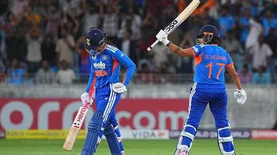 Two cricket players on the field celebrating a run Two cricket players on the field celebrating a run