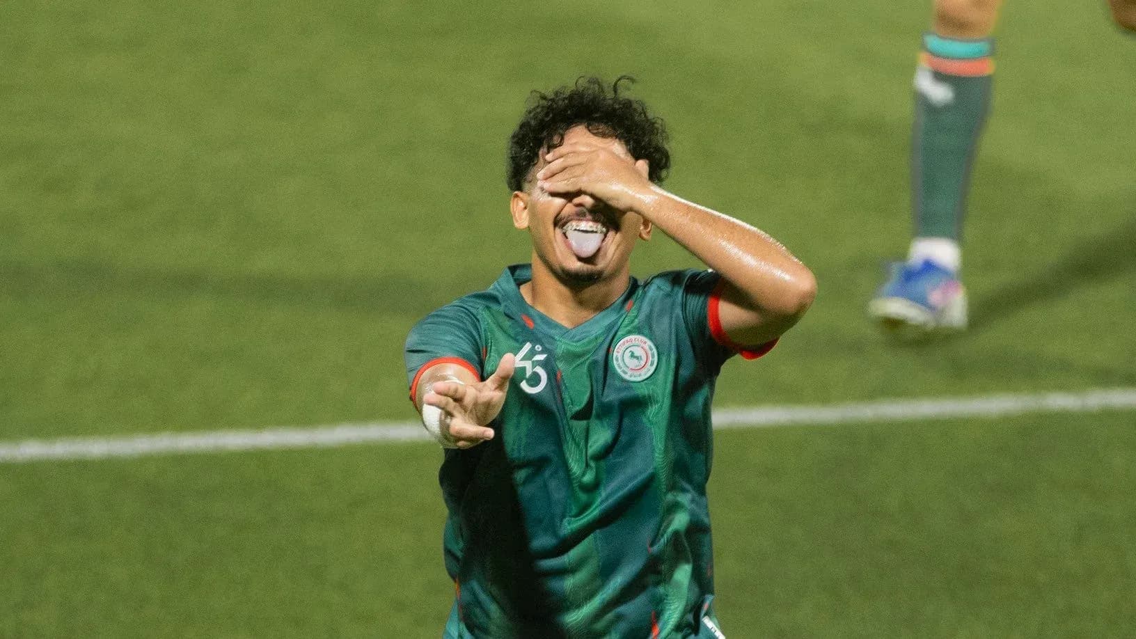 Player celebrating with hand over face on field Player celebrating with hand over face on field