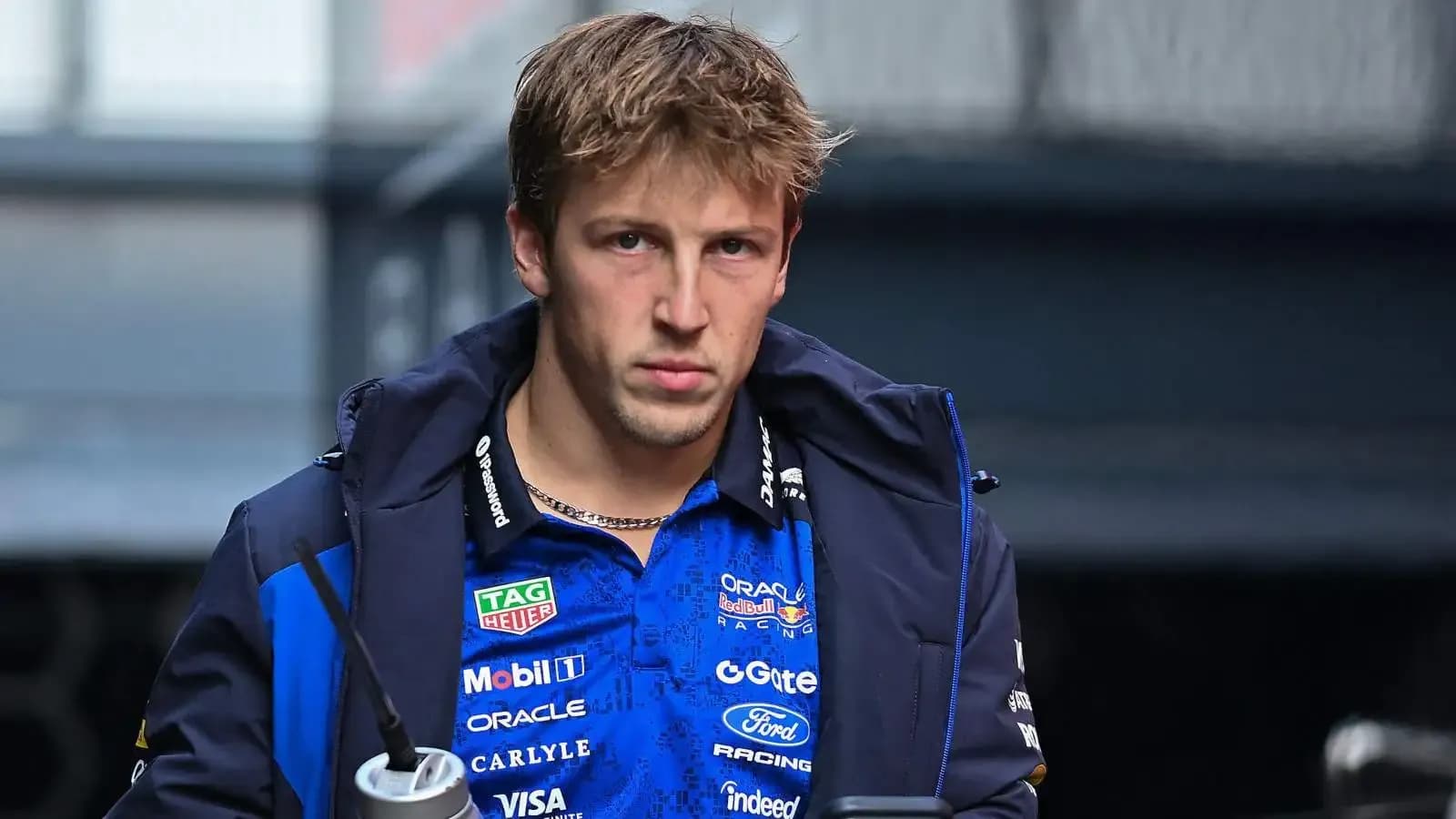 Driver in team jacket holding a drink Driver in team jacket holding a drink