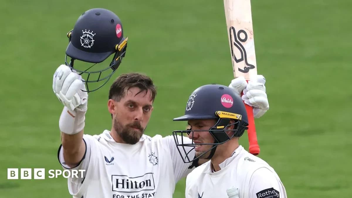 Cricketer celebrating a milestone with teammate Cricketer celebrating a milestone with teammate