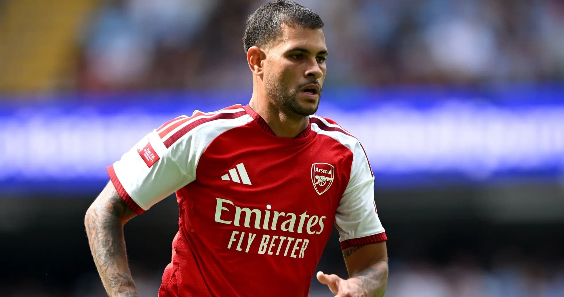 Player in Arsenal jersey running on the pitch Player in Arsenal jersey running on the pitch