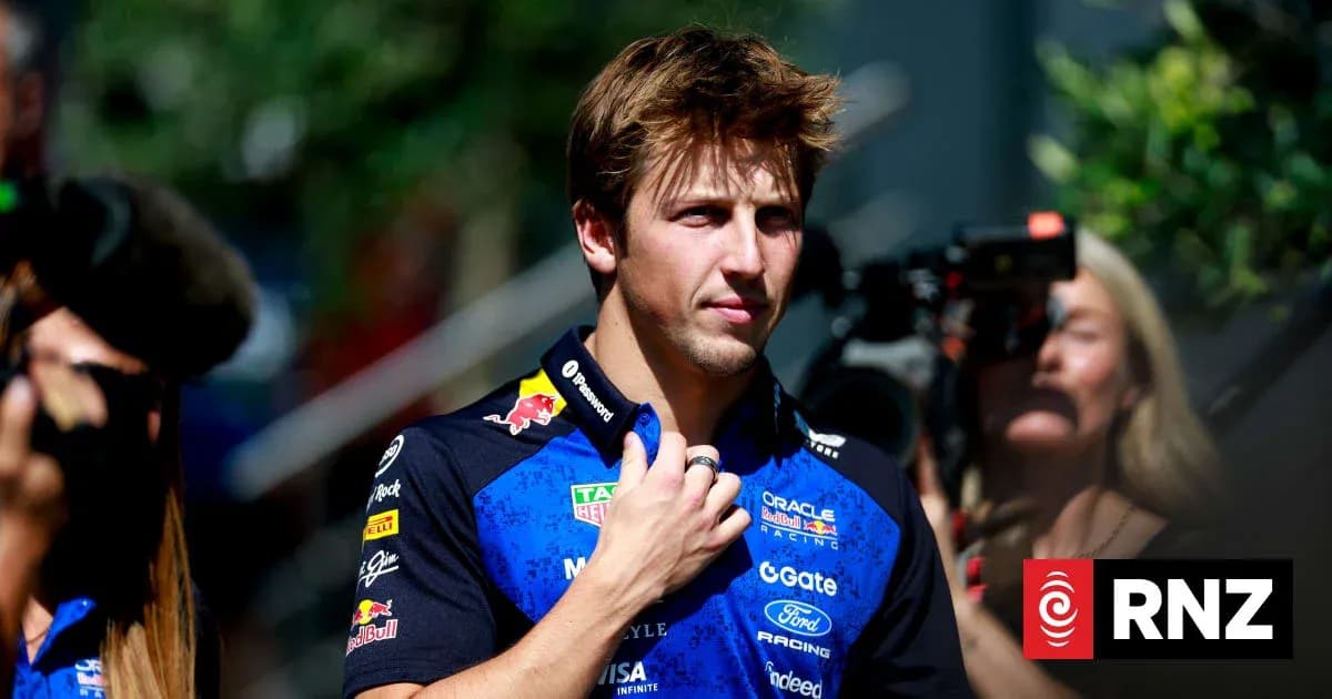 Driver in team uniform at event, cameras present Driver in team uniform at event, cameras present