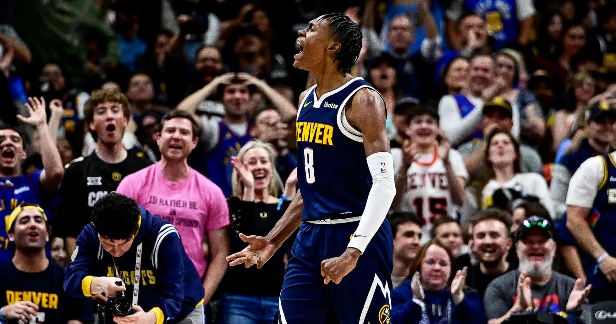Denver player celebrating with enthusiastic crowd behind Denver player celebrating with enthusiastic crowd behind
