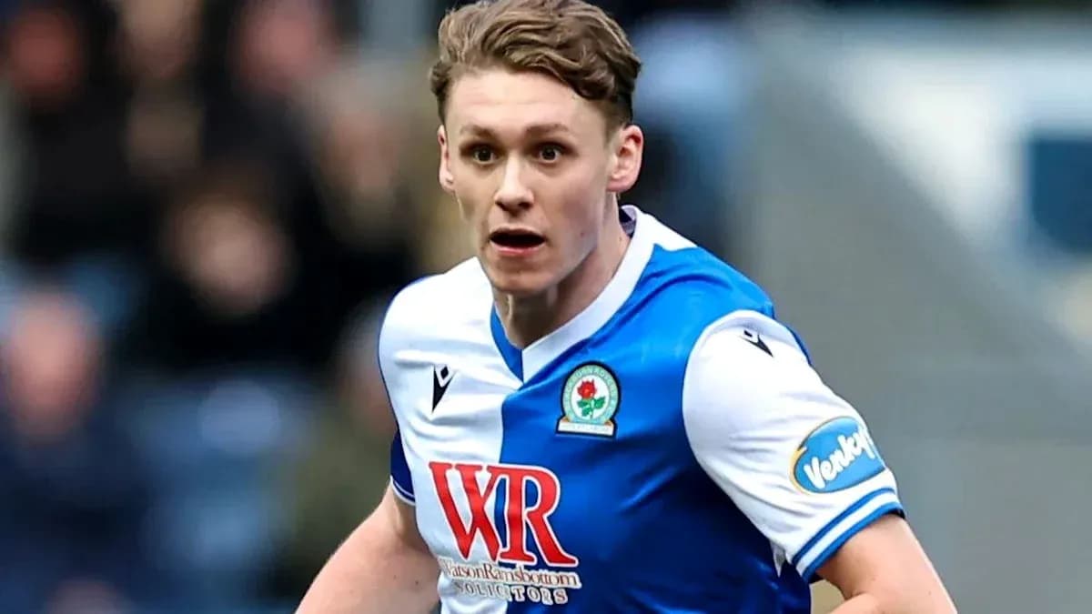 Player in Blackburn Rovers jersey running on field Player in Blackburn Rovers jersey running on field