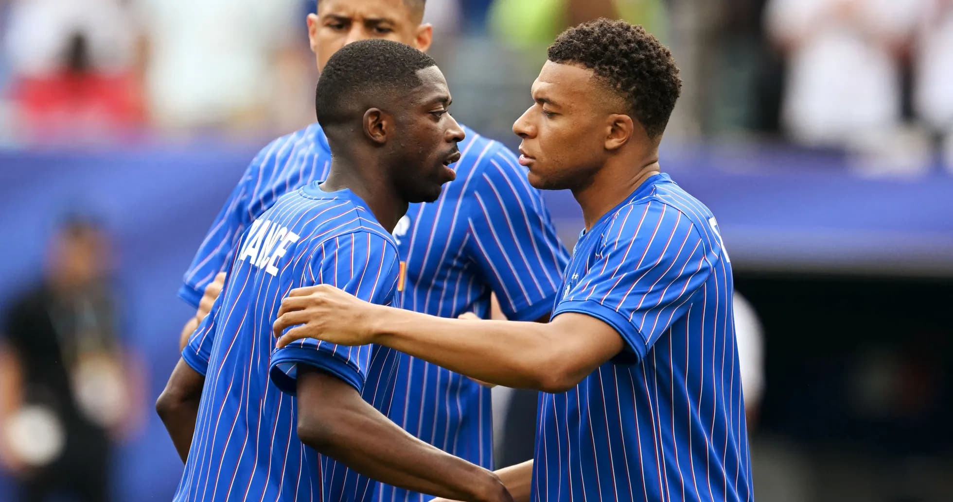 Two players in blue jerseys discussing on the field Two players in blue jerseys discussing on the field