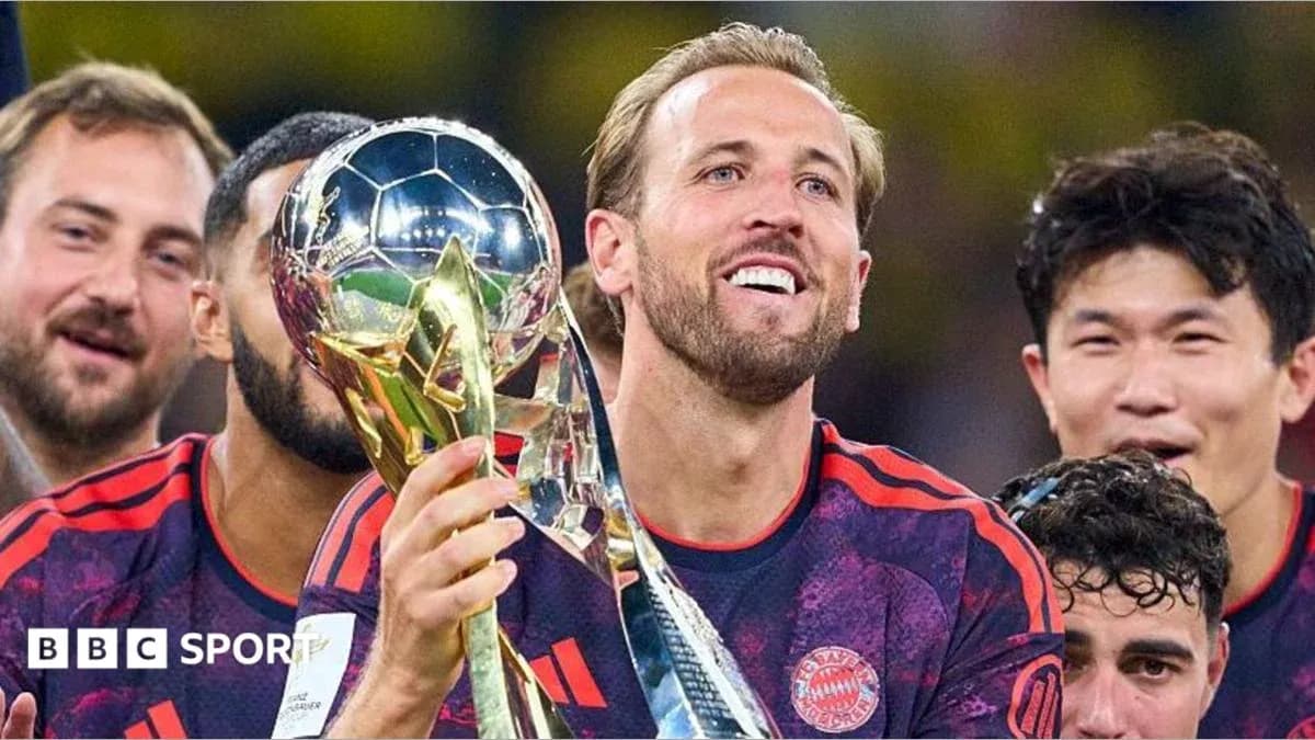 Player holding trophy with teammates celebrating behind Player holding trophy with teammates celebrating behind