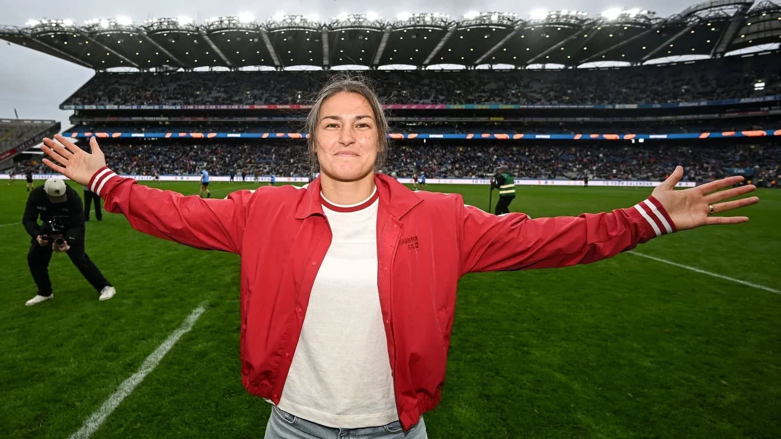 Woman in red jacket celebrating on football field Woman in red jacket celebrating on football field