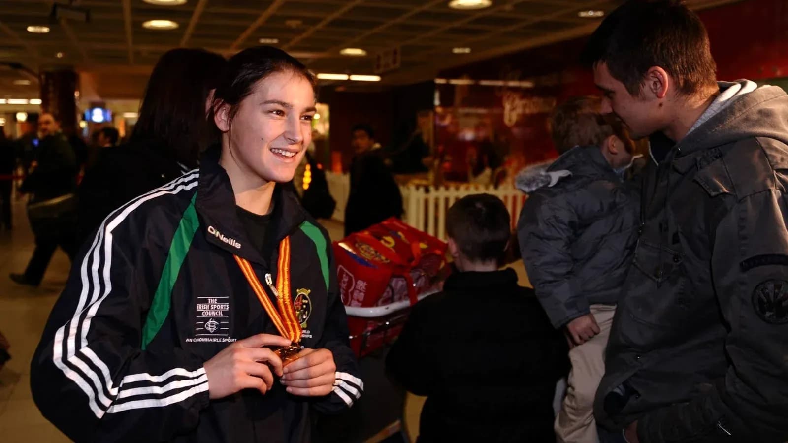 Athlete holding medal at an airport arrival area Athlete holding medal at an airport arrival area