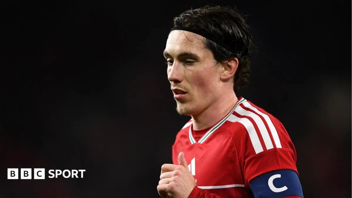 Player in red jersey with captain's armband Player in red jersey with captain's armband