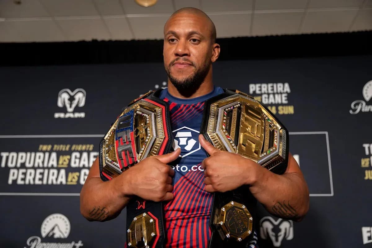 Fighter displaying multiple championship belts at event Fighter displaying multiple championship belts at event