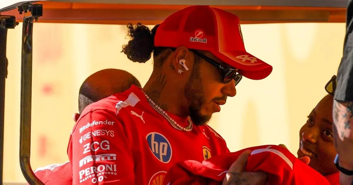 Driver in Ferrari uniform interacting with team members Driver in Ferrari uniform interacting with team members