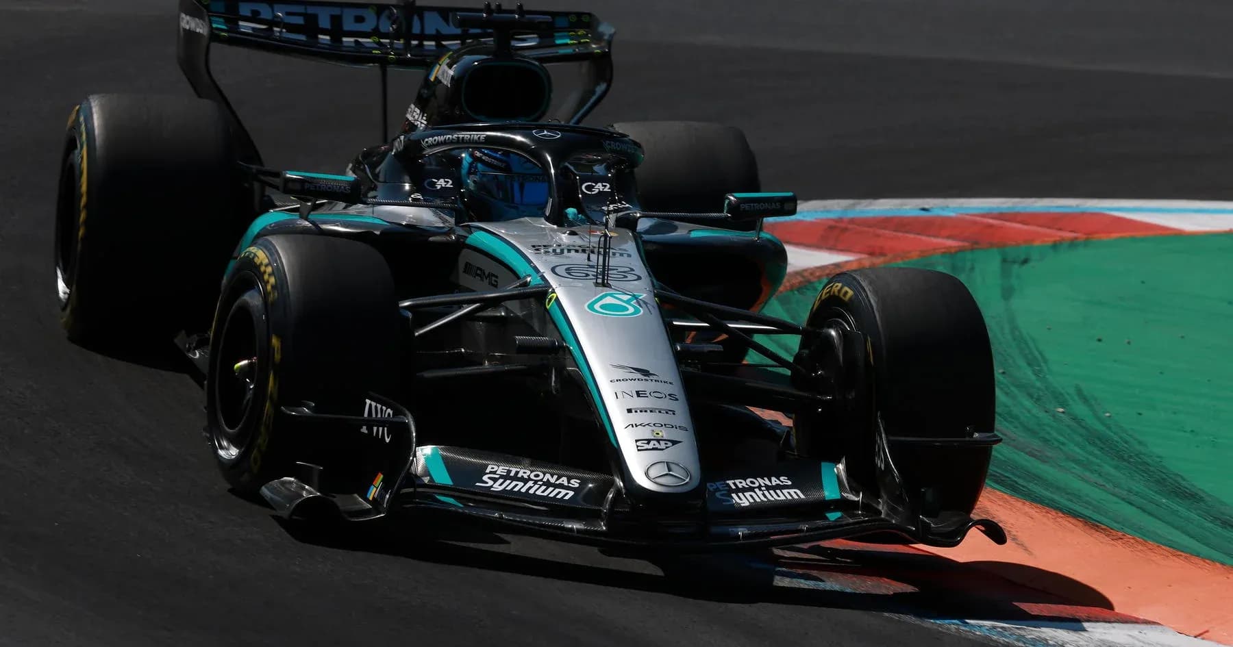 Mercedes Formula 1 car navigating a corner on track Mercedes Formula 1 car navigating a corner on track