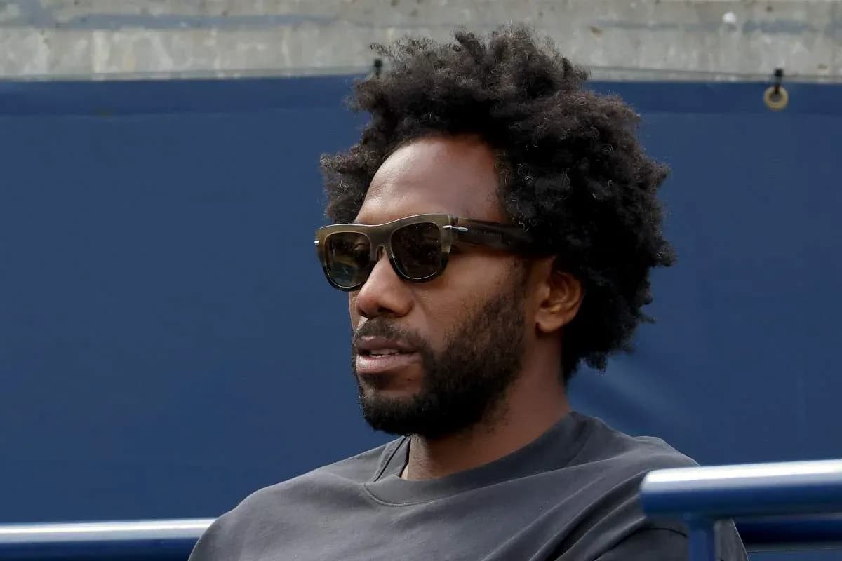 Man wearing sunglasses sitting on bleachers Man wearing sunglasses sitting on bleachers