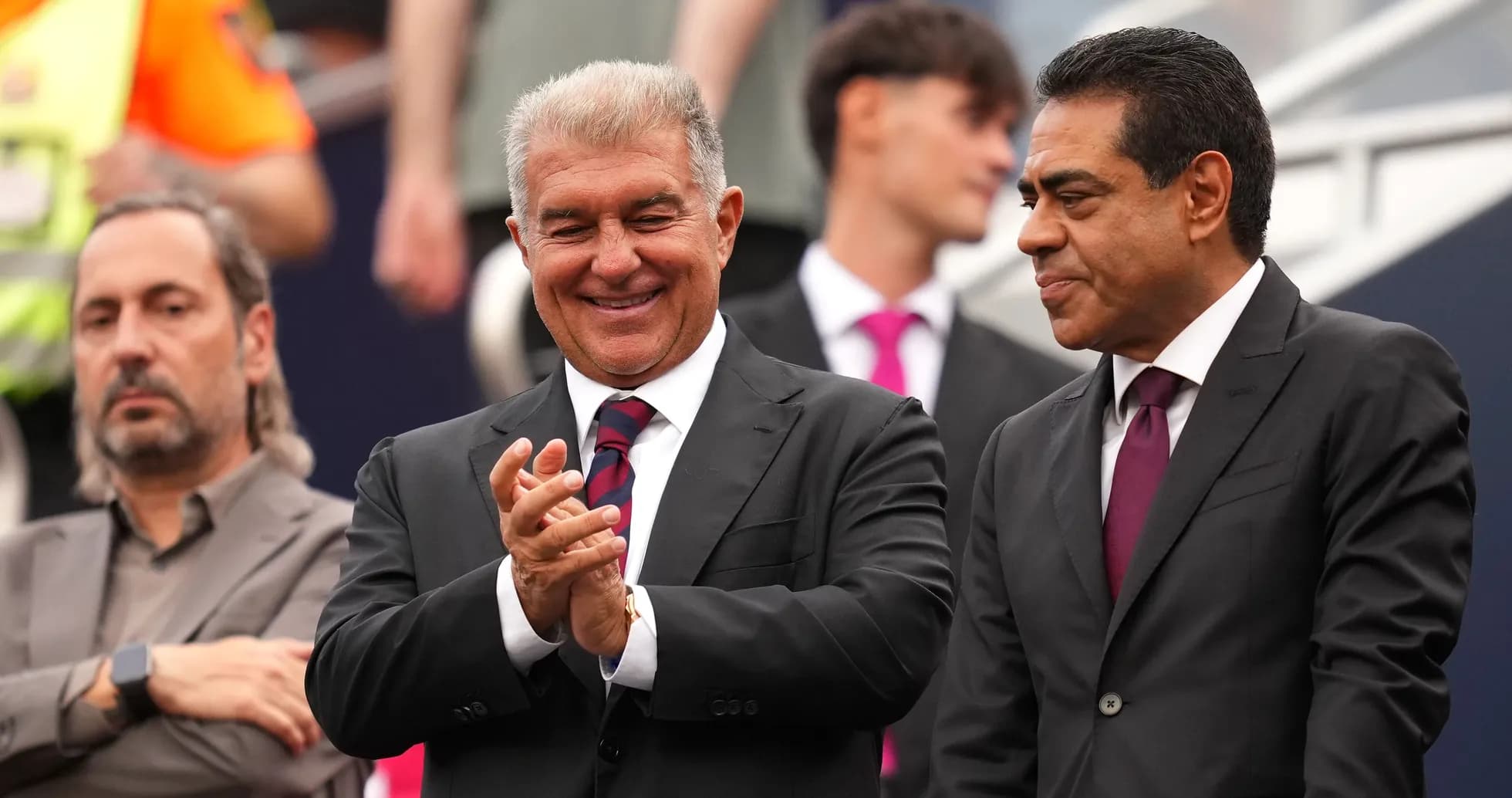 Officials smiling and applauding during an event Officials smiling and applauding during an event