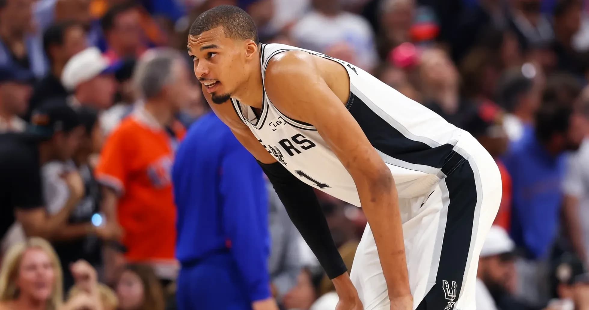 Player in Spurs uniform during intense game moment Player in Spurs uniform during intense game moment