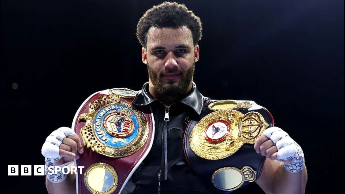 Boxer holding championship belts in the ring Boxer holding championship belts in the ring
