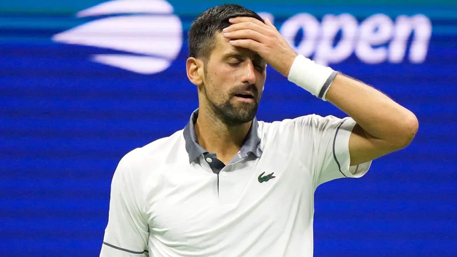 Tennis player with hand on forehead during match Tennis player with hand on forehead during match