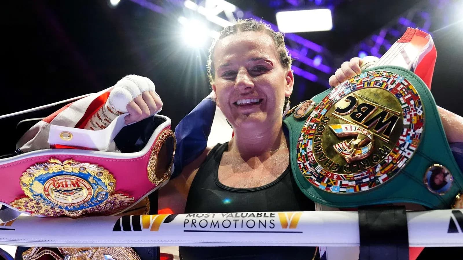 Boxer celebrating with championship belts after match Boxer celebrating with championship belts after match