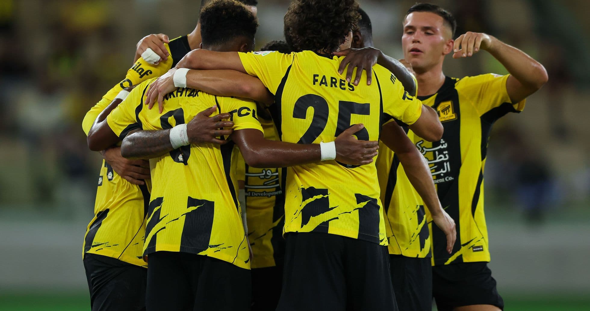 Players celebrating a goal in yellow jerseys Players celebrating a goal in yellow jerseys